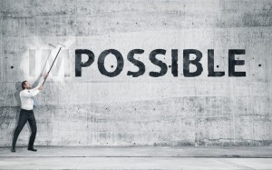 Man turning the word "Impossible" into "Possible"